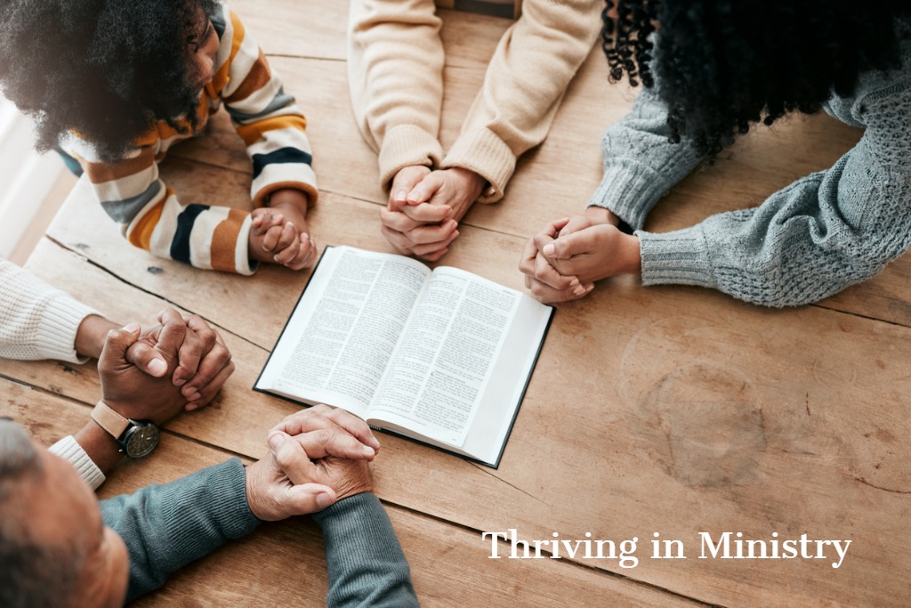 Students praying around a Bible