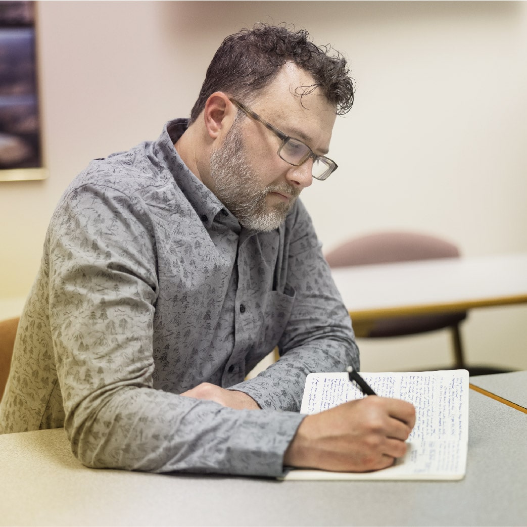 student writing in a notebook