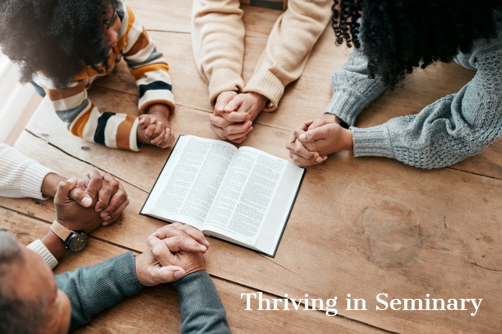 people praying around a Bible